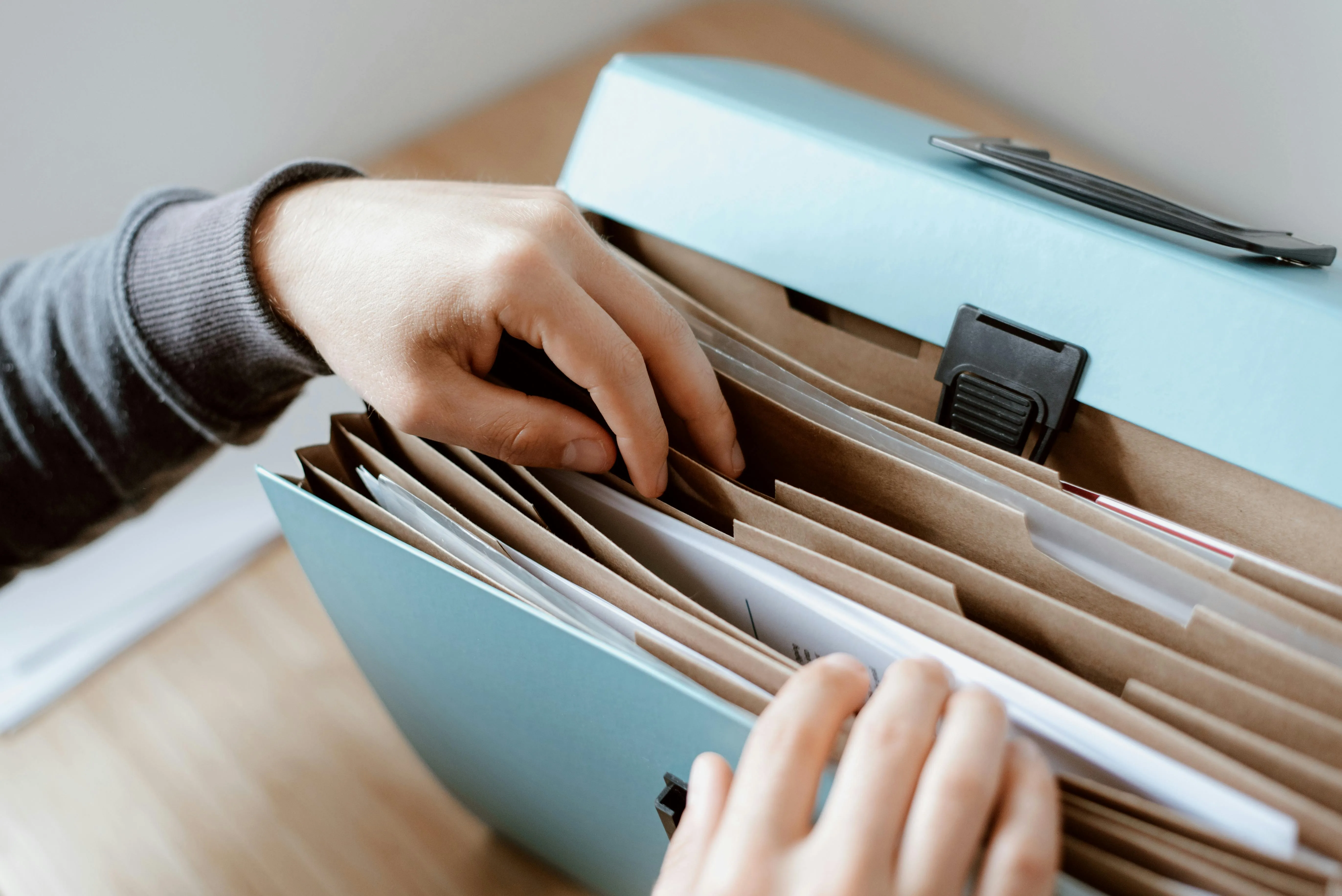 A person going through their folder to search for something, symbolizing the need for digitalization.